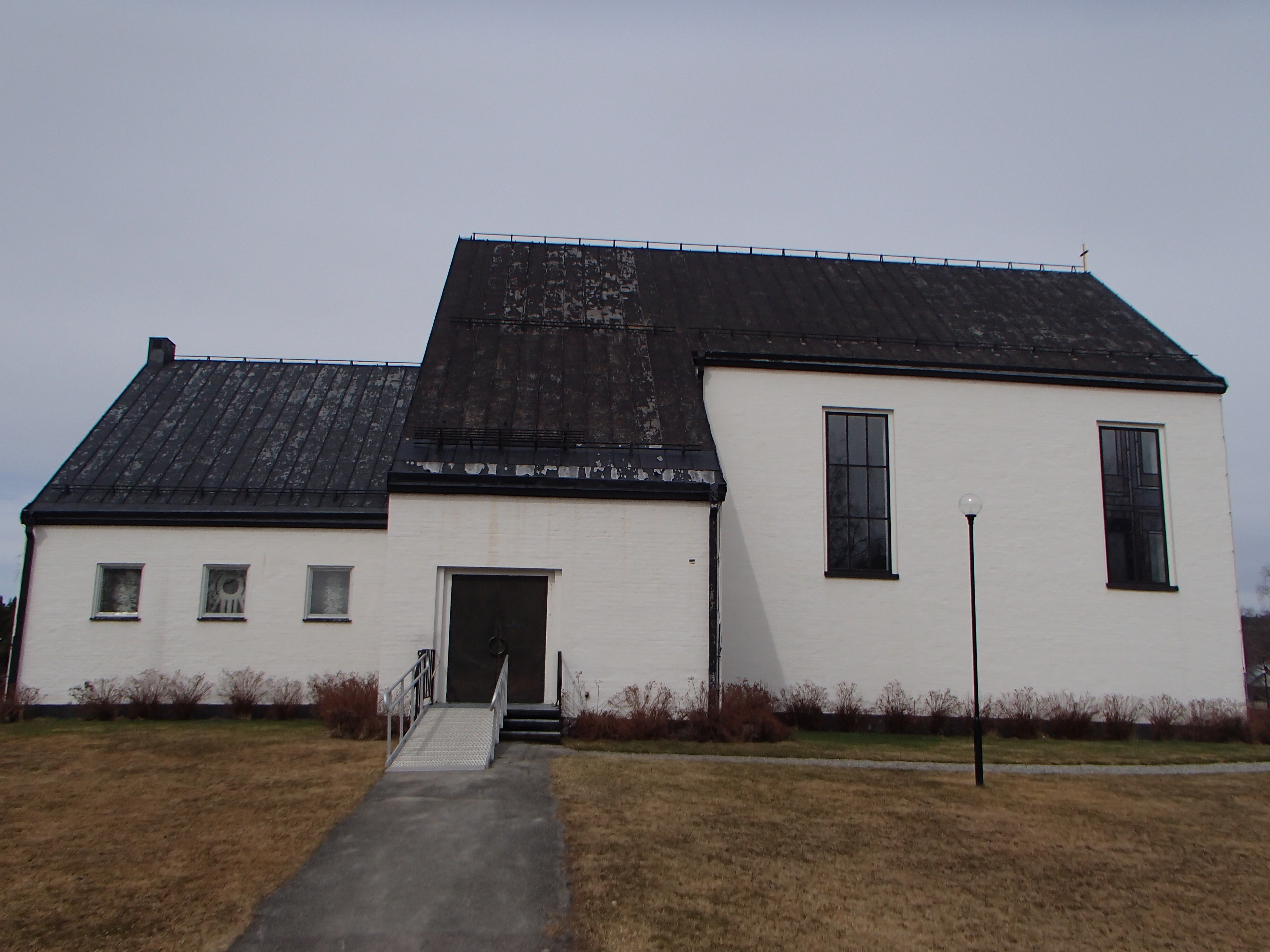 Ånge kyrka, vit kyrka med svart tak och kyrkogård.