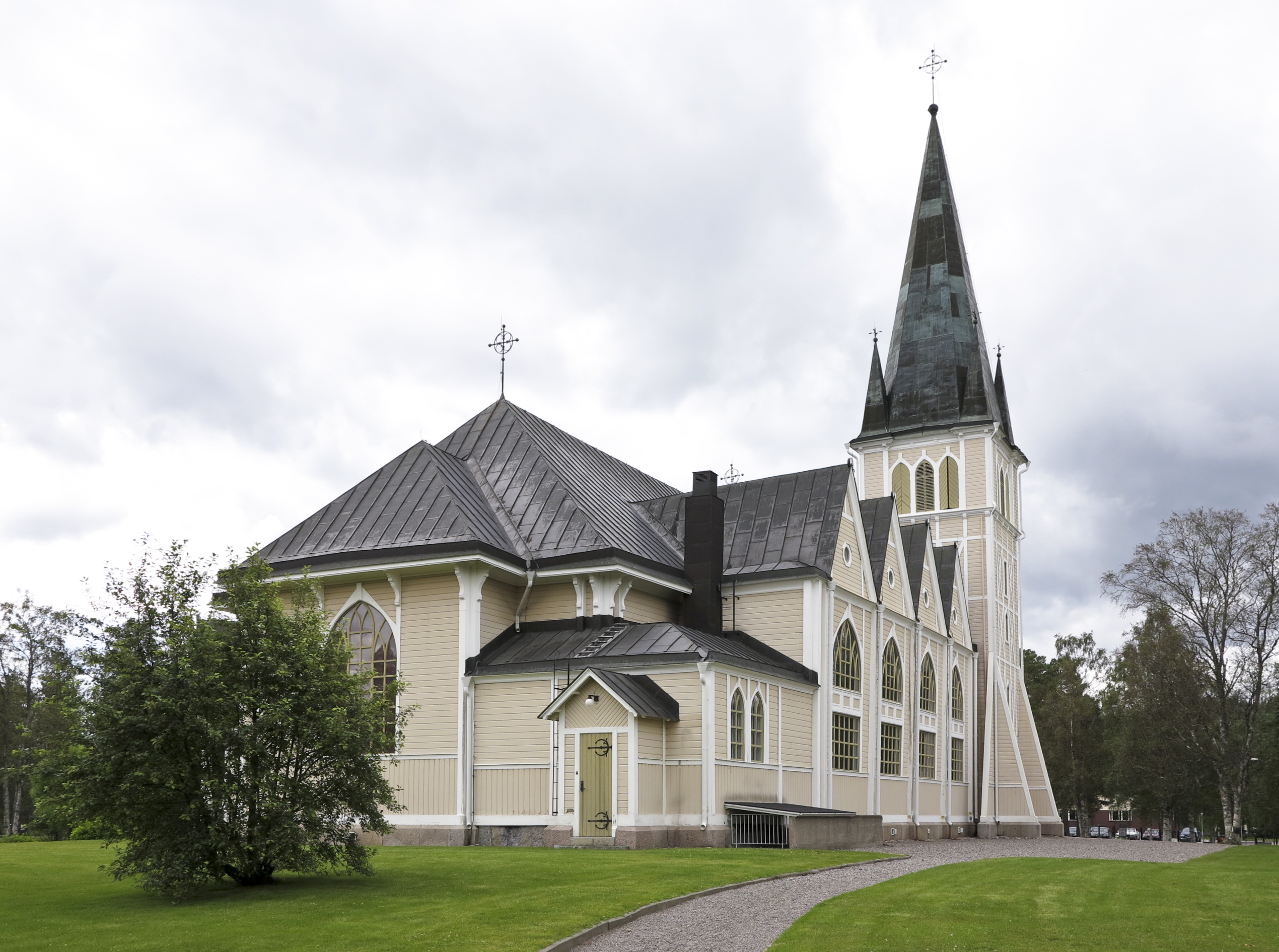 Arvidsjaurs kyrka, träkyrka med torn mot sommarhimmel.