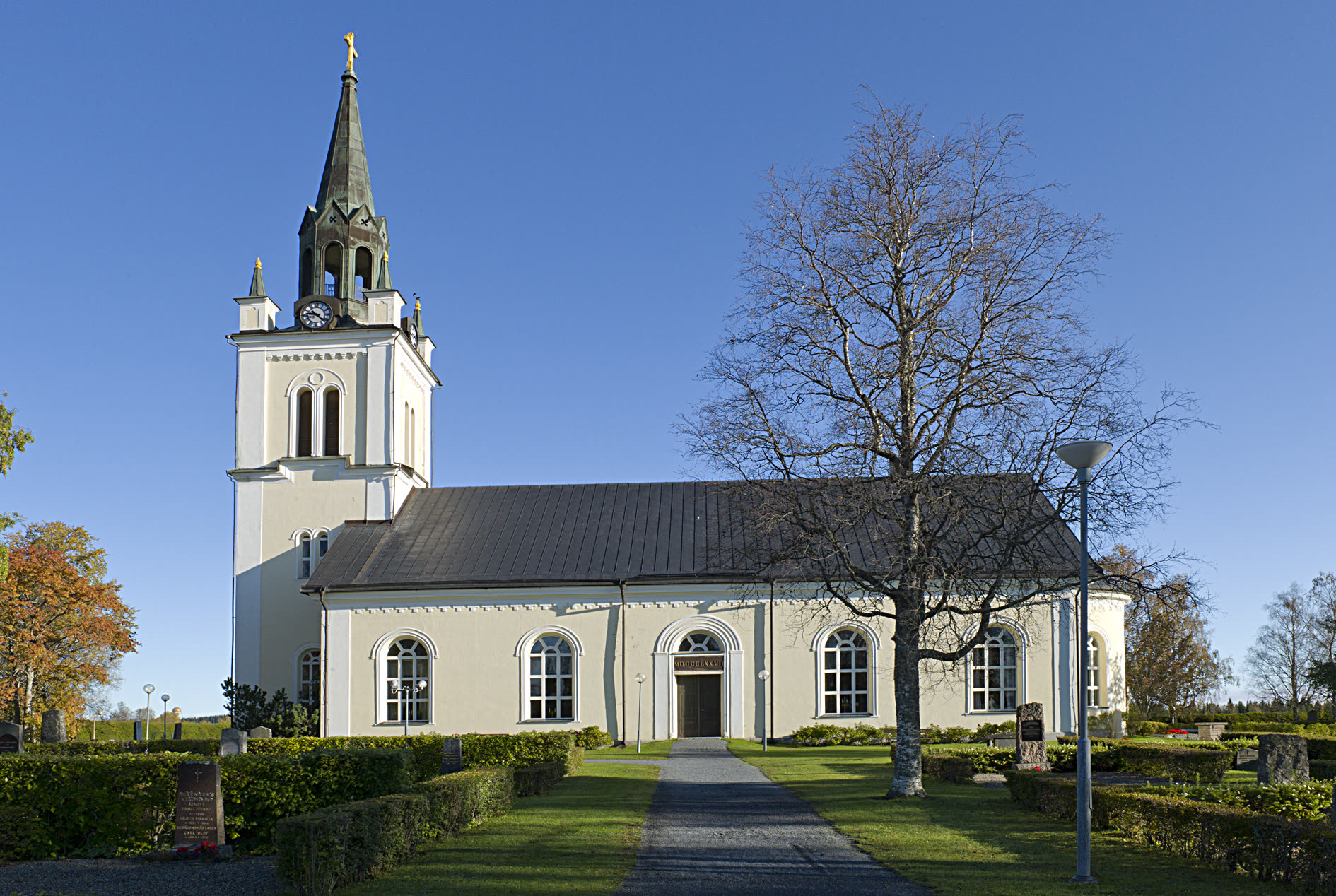 Ås kyrka i Krokom, stenkyrka med torn mot Jämtlandshimmel.