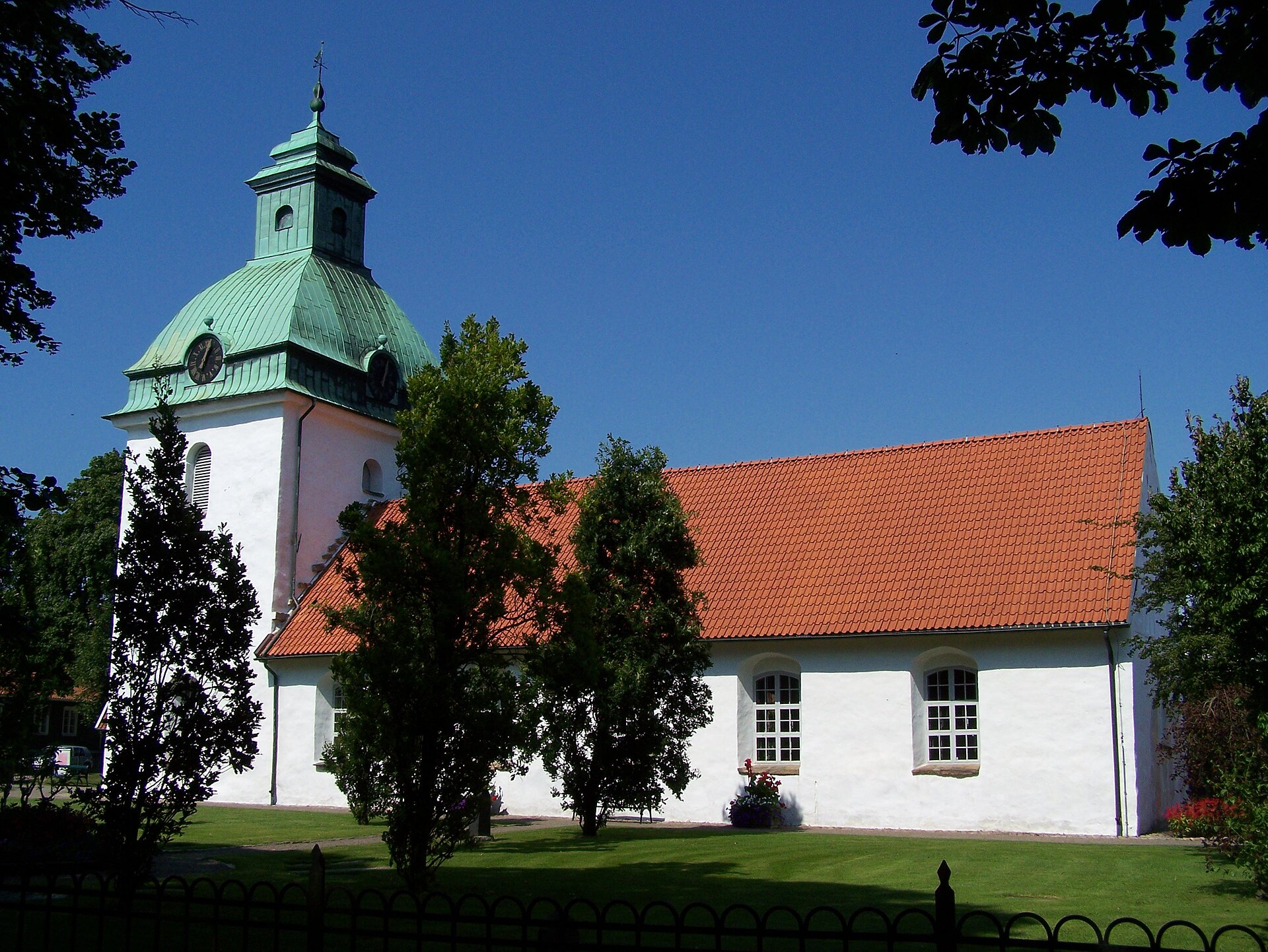 Sankt Laurentii kyrka i Falkenberg, vit kyrka med torn.