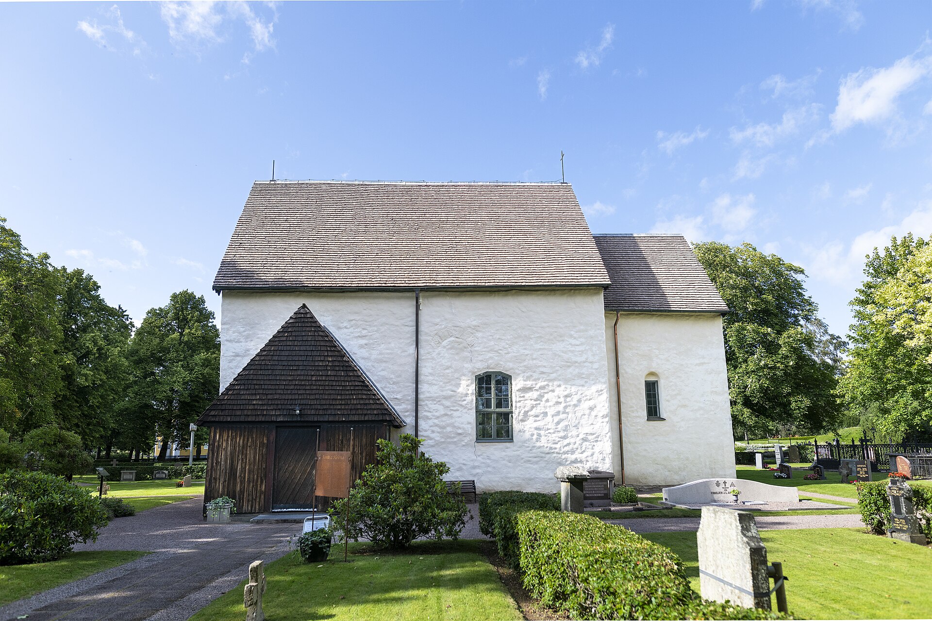 Götene kyrka, stenkyrka med torn mot himlen.