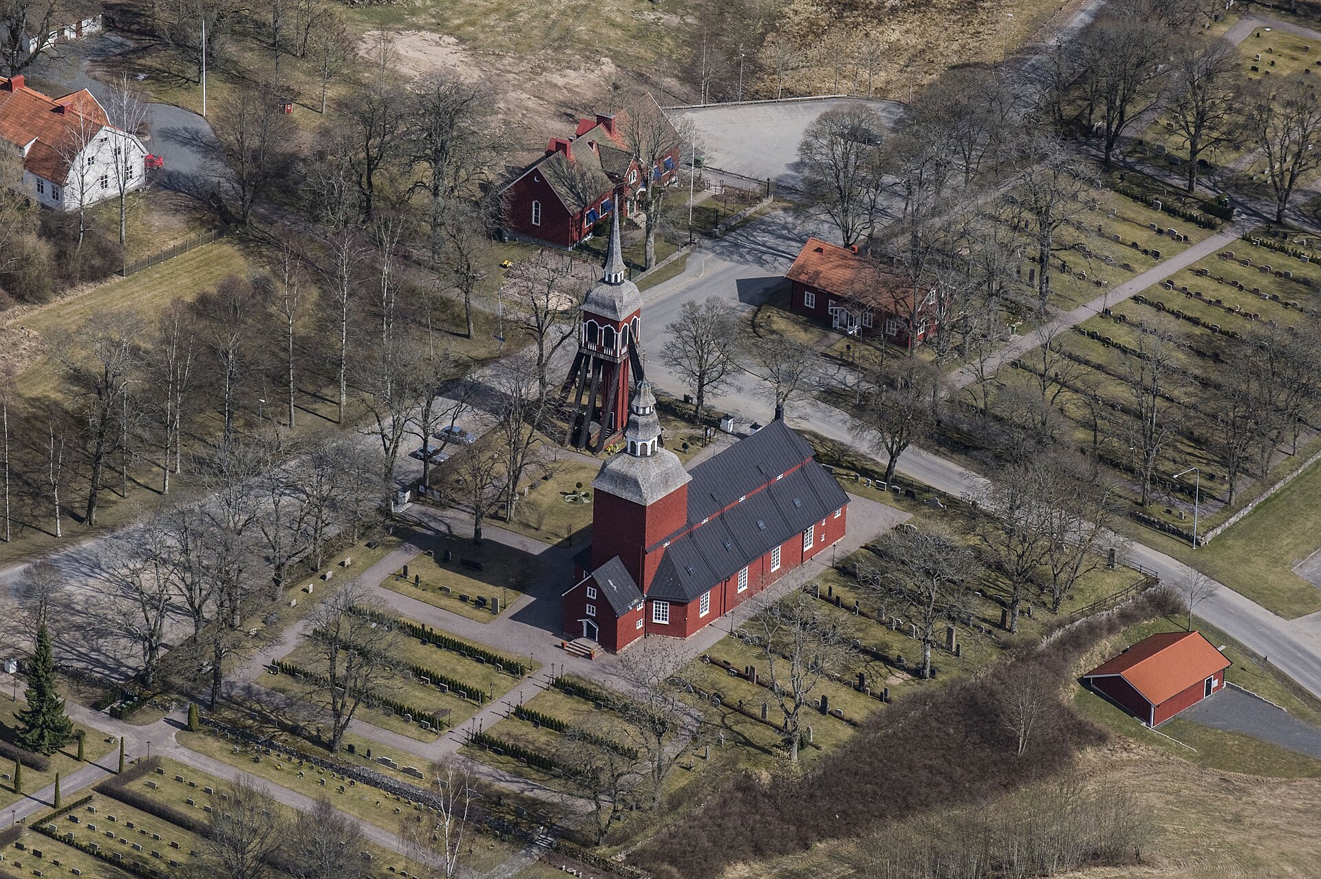 Habo kyrka, röd träkyrka med torn mot grönska.