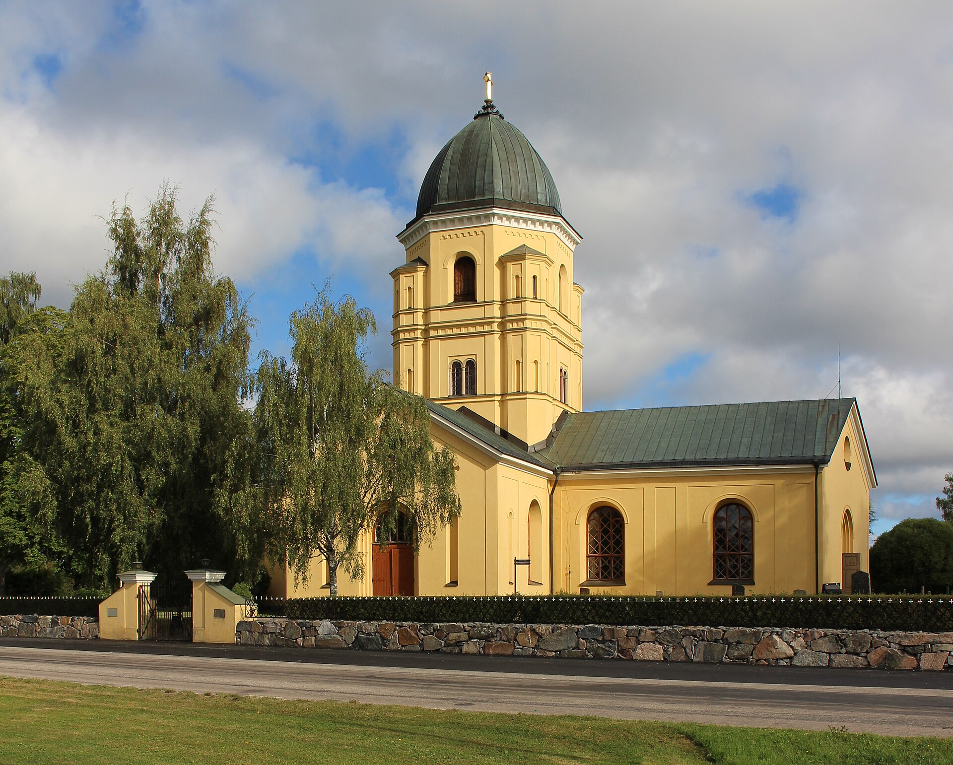 Hållnäs kyrka sett från sydost, vit kyrka med torn.
