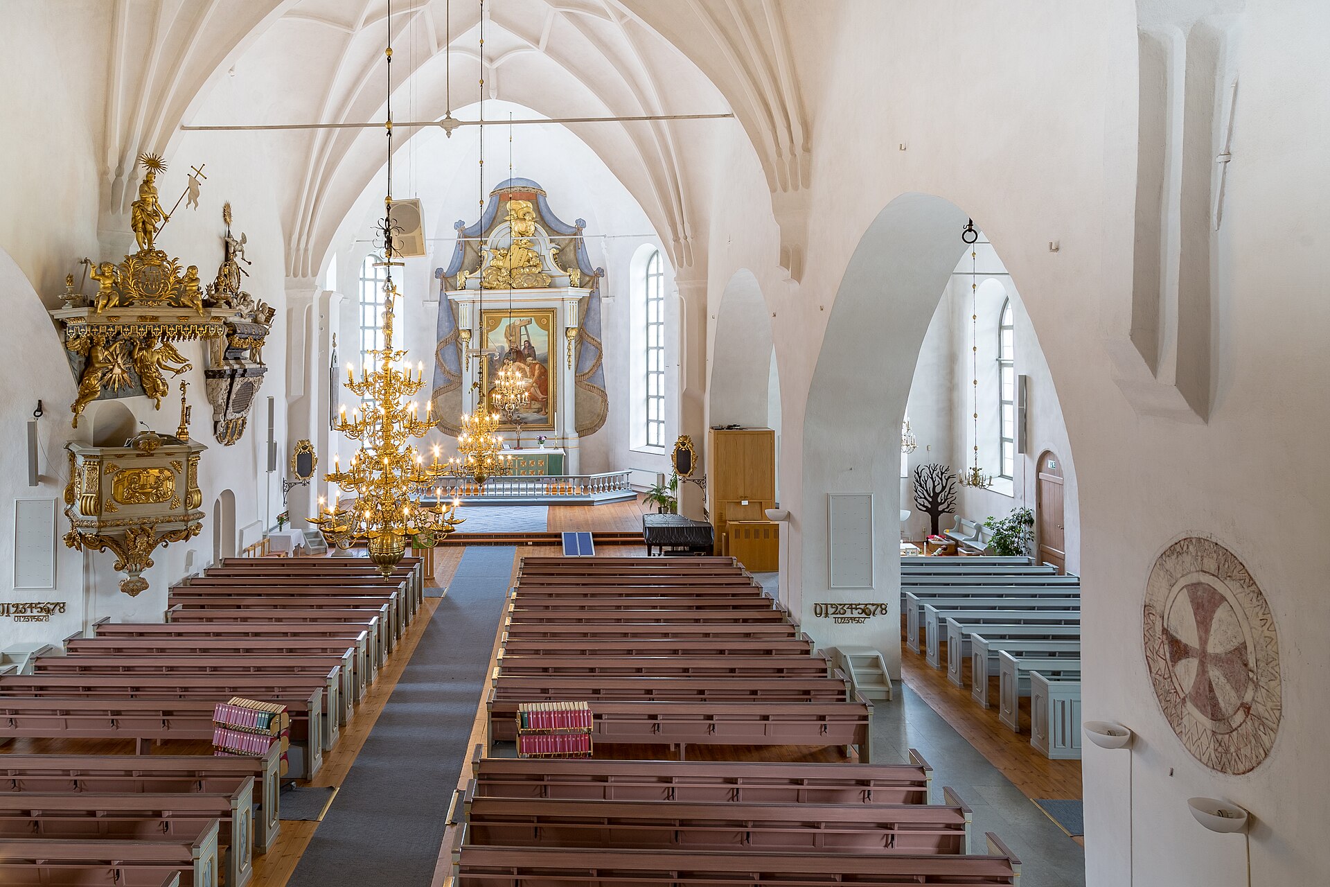 Hedemora kyrka, stenkyrka med torn mot sommarhimmel.