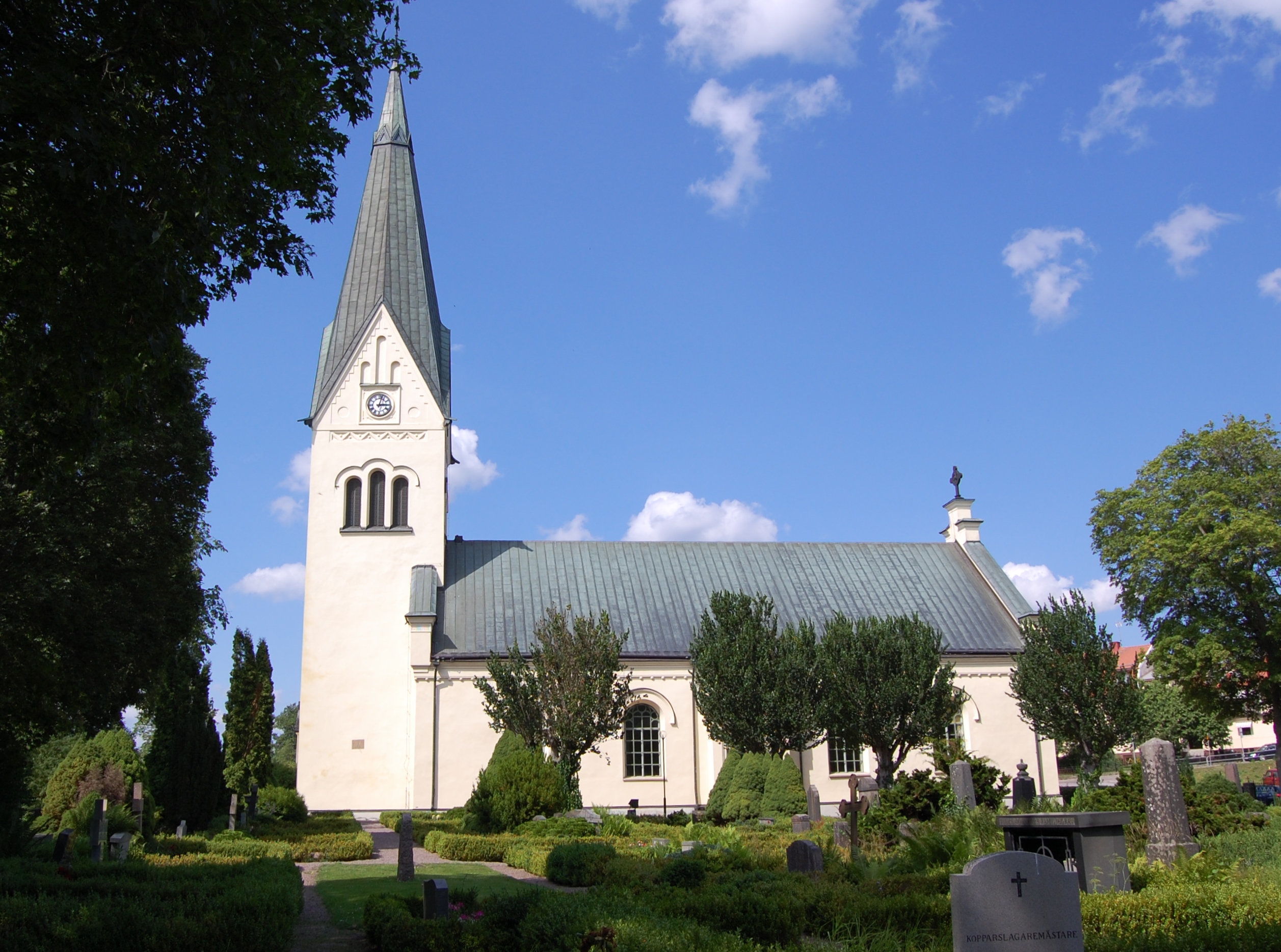 Högsby kyrka, vit kyrka med svart tak och torn.