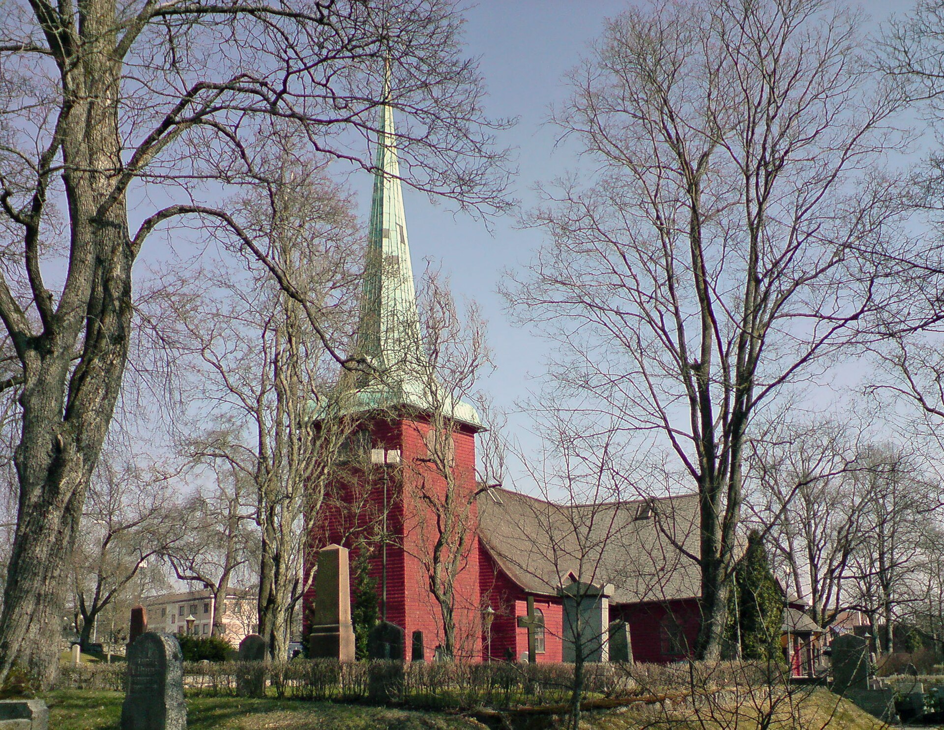 Karlskoga kyrka, tegelkyrka med torn en vårdag.