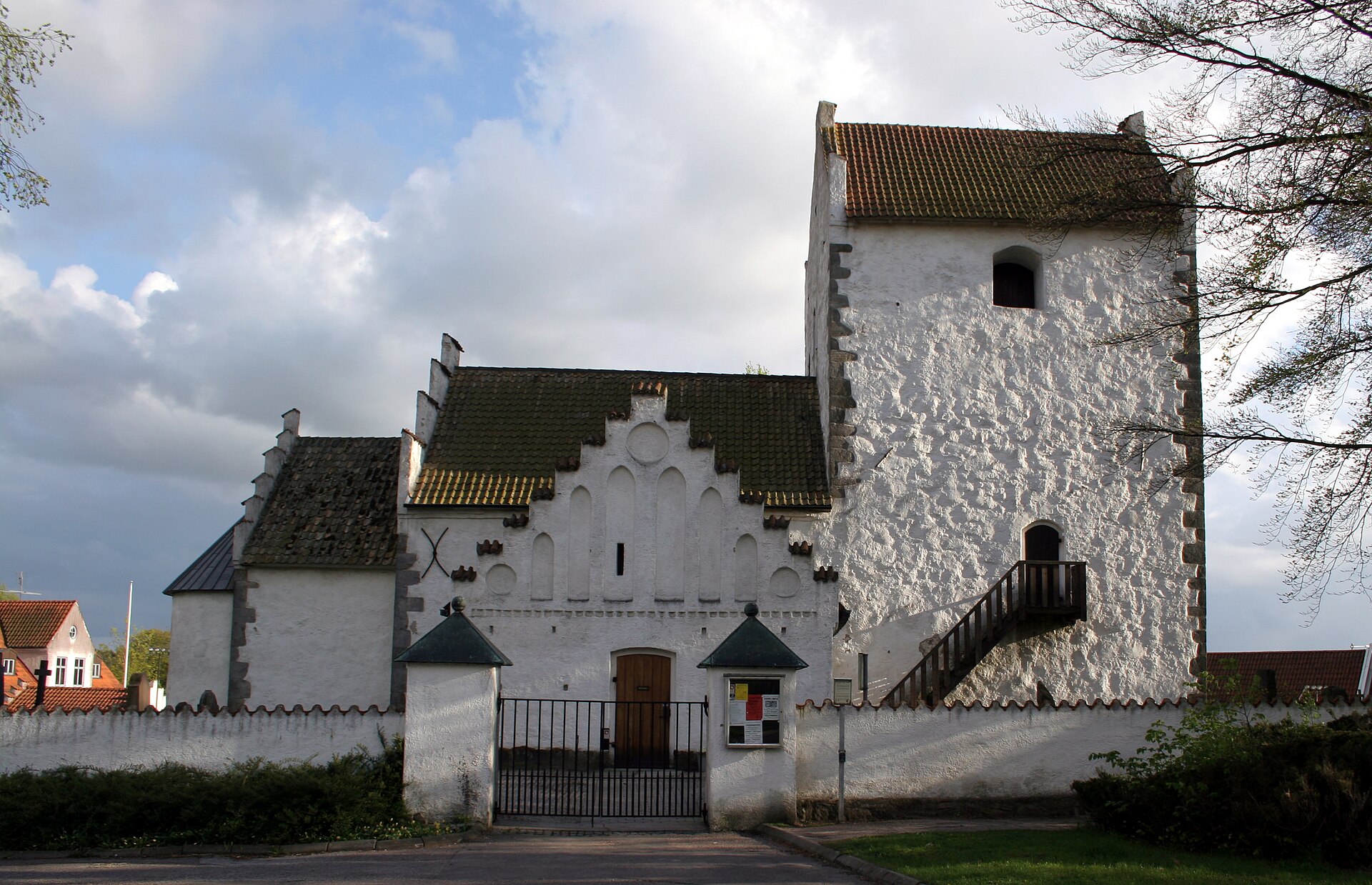 Kävlinge gamla kyrka, stenkyrka med torn mot himlen.