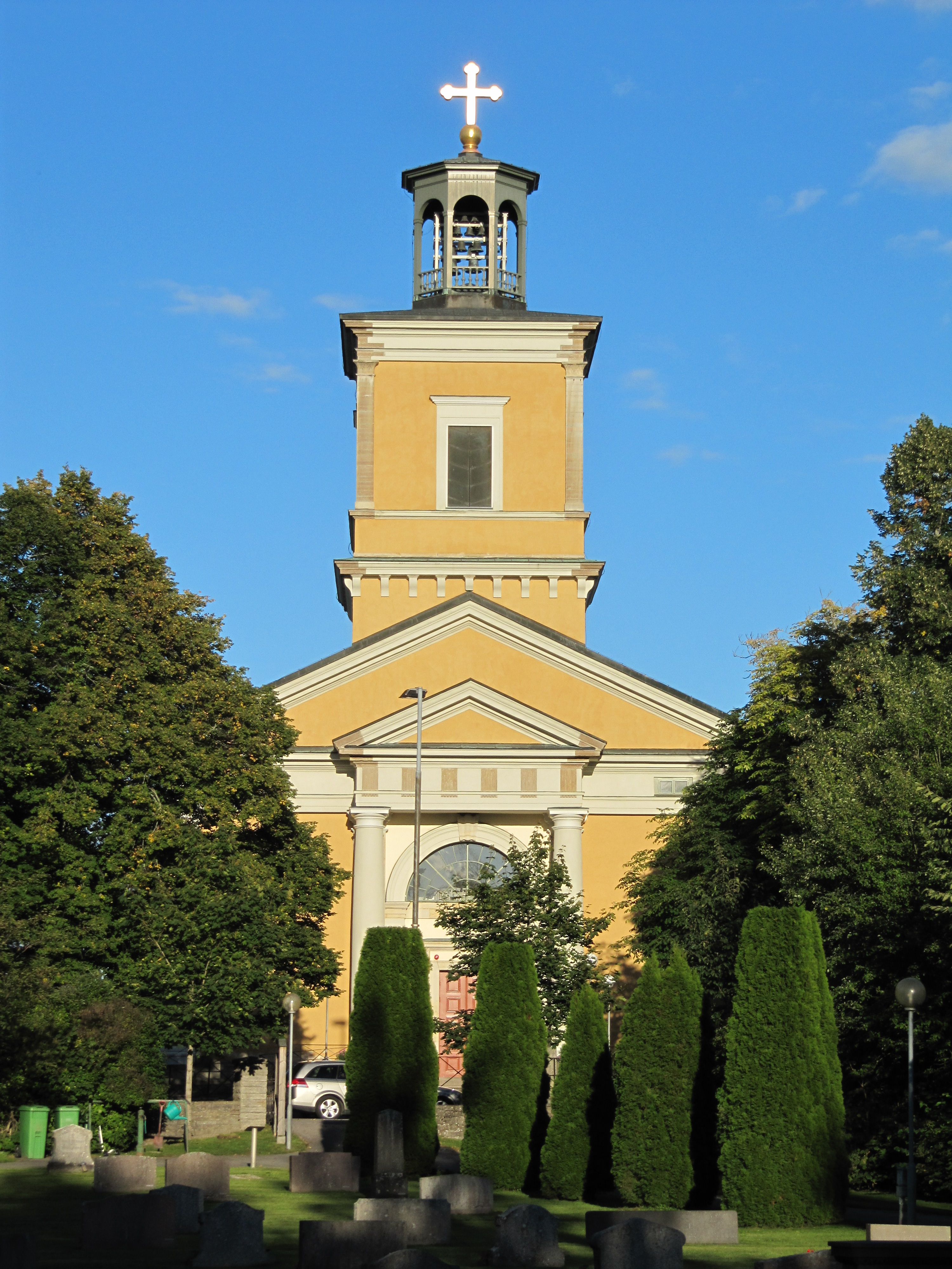 Kumla kyrka i Närke, stenkyrka med torn mot himlen.