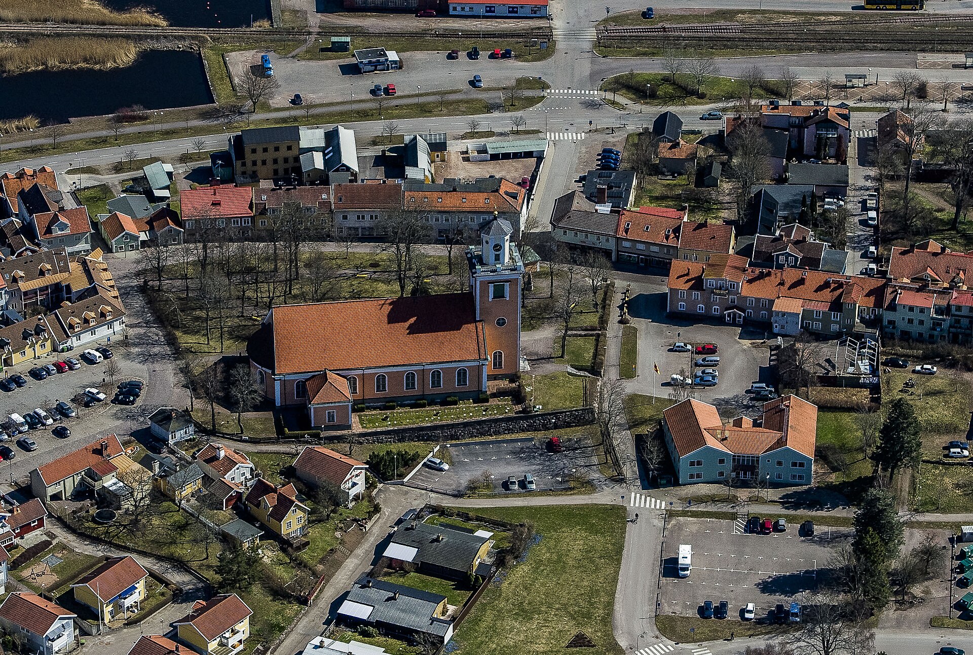 Mönsterås kyrka från luften, vit kyrka med torn vid Kalmarsund.