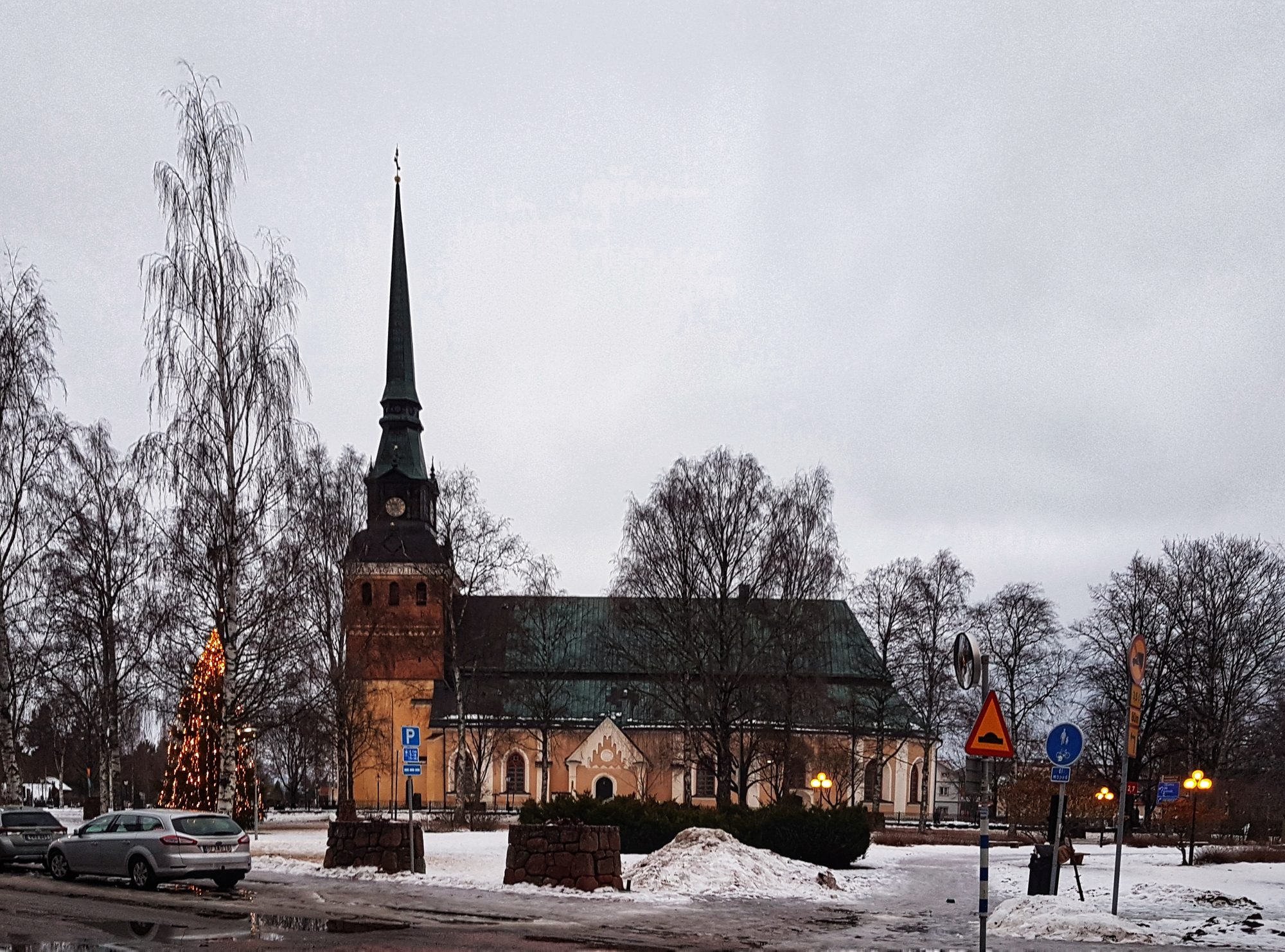 Mora kyrka, stenkyrka med torn mot sommarhimmel.