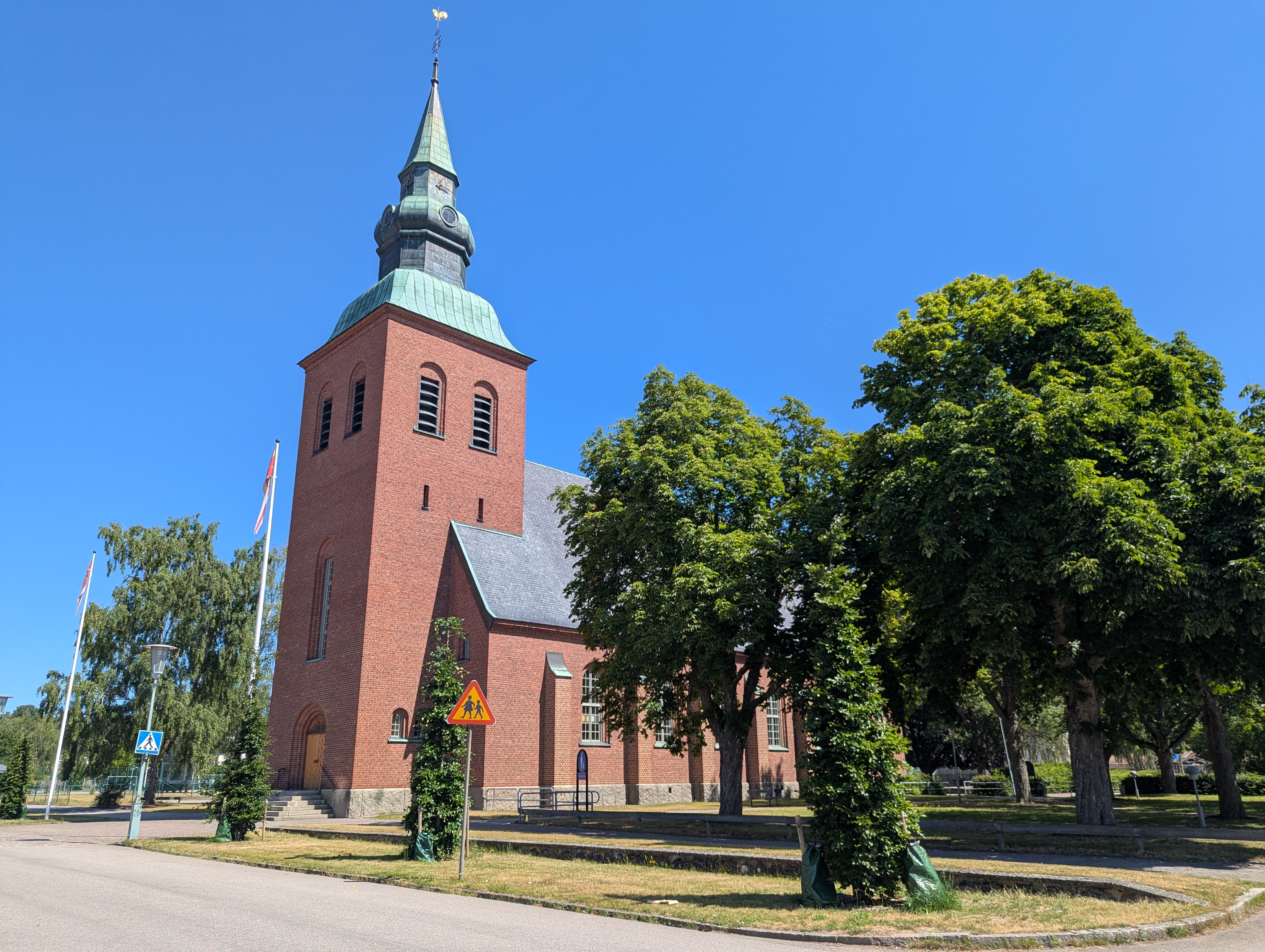 Nybro kyrka, kyrka med torn mot sommarhimmel.