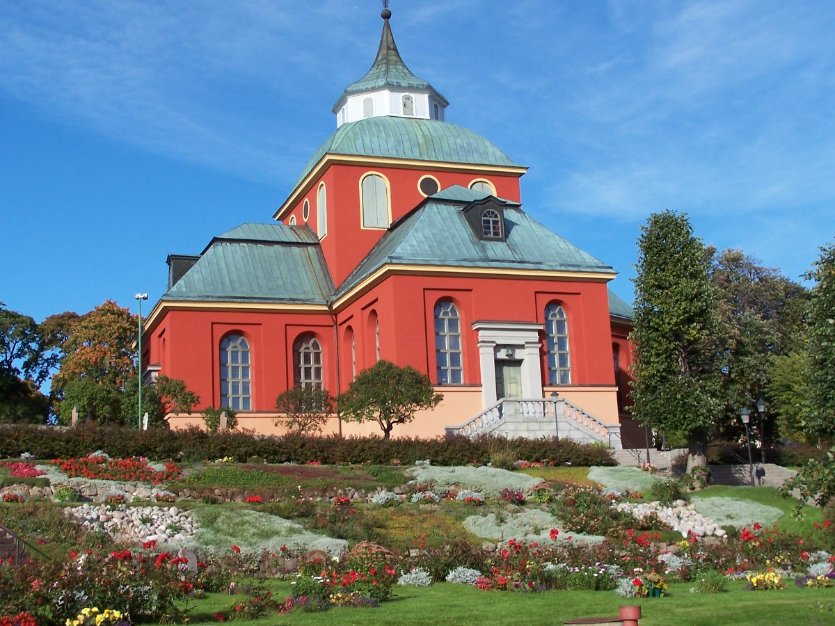 Söderhamns kyrka, stenkyrka med torn mot himlen.