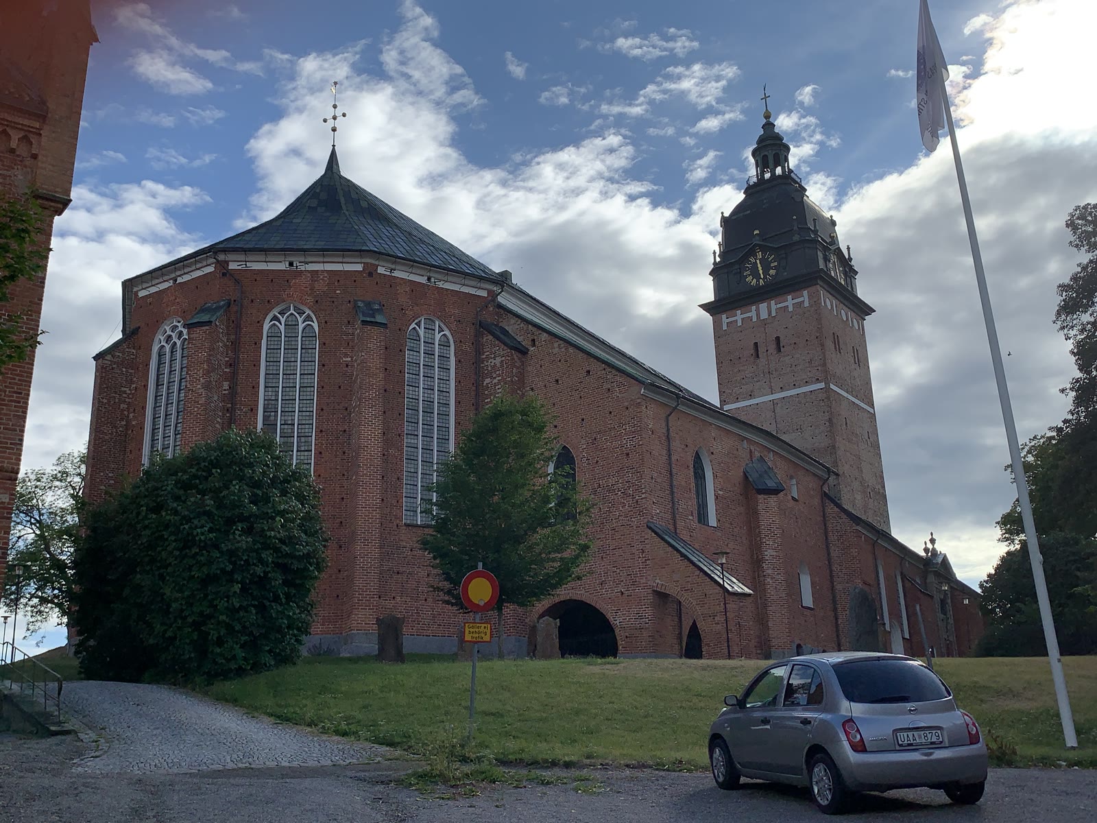 Strängnäs domkyrka, tegelkyrka med torn mot sommarhimmel.