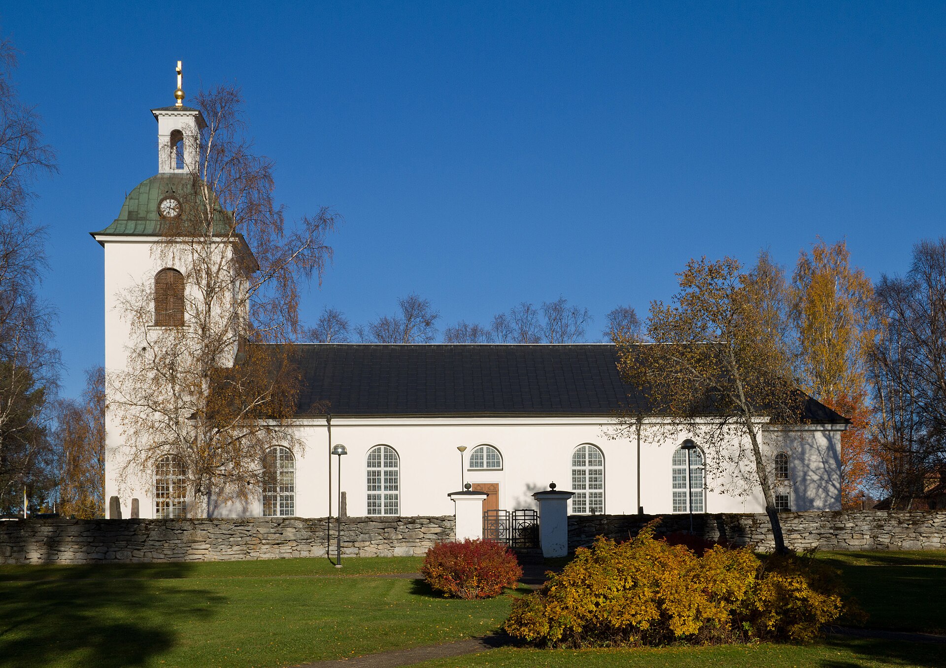 Ströms kyrka i Strömsund, vit kyrka med torn mot vattnet.