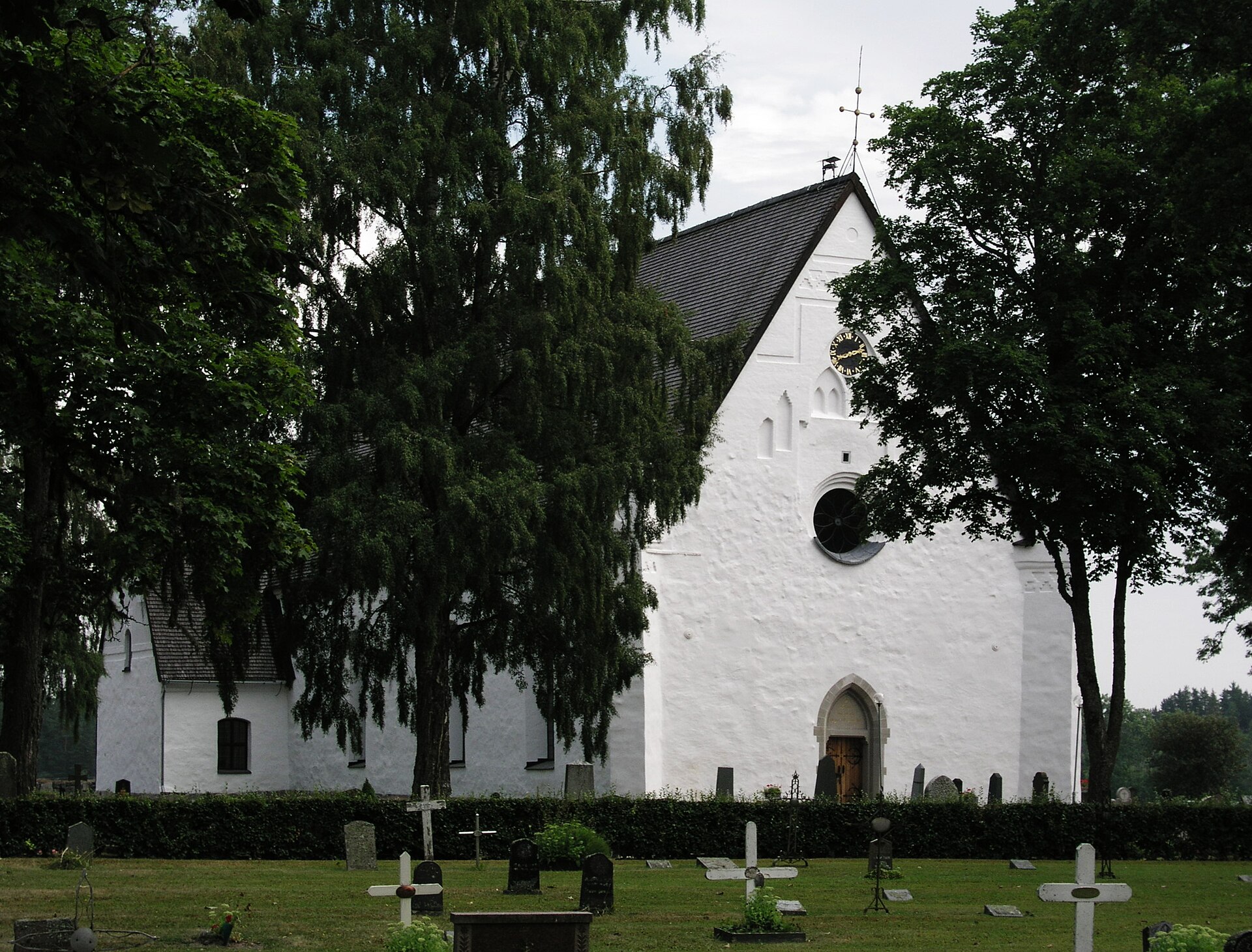 Tierps kyrka, stenkyrka med torn mot himlen.