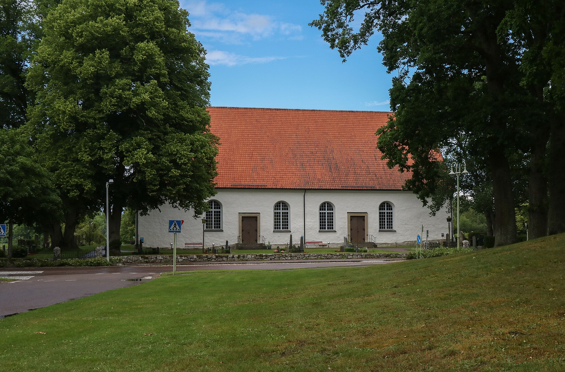 Torsås kyrka, vit kyrka med torn fotograferad utifrån.