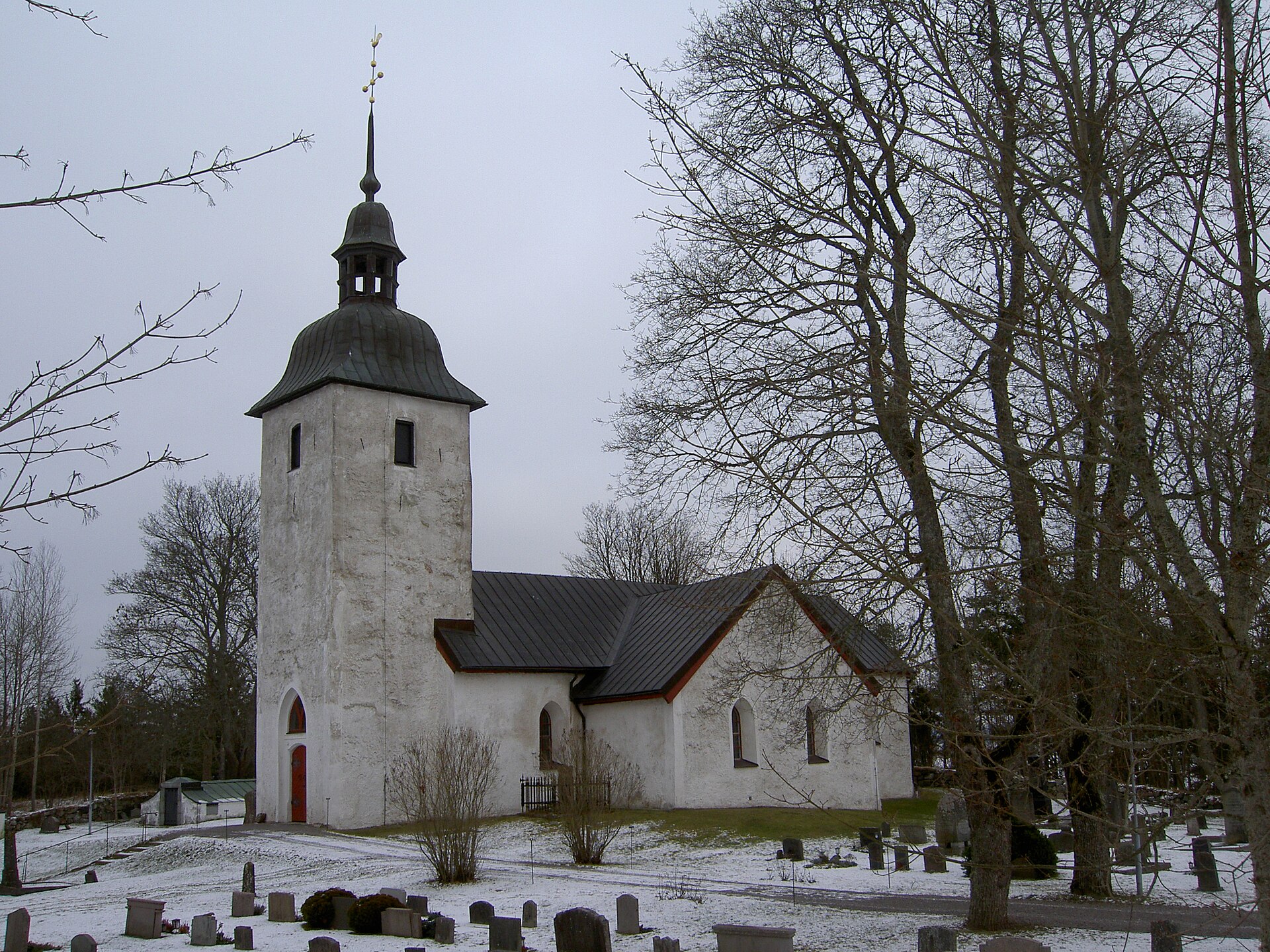 Ytterjärna kyrka, vit kyrka med torn, fotograferad utifrån.